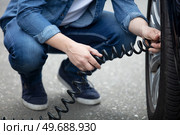 a man with a wheel flat tire in parking. Стоковое фото, агентство Ingram Publishing / Фотобанк Лори