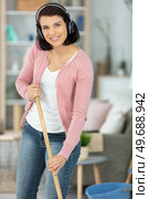 girl in headphones washing floor with mop in living room. Стоковое фото, агентство Ingram Publishing / Фотобанк Лори