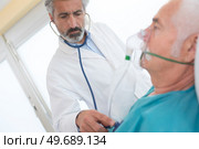 senior man inhaling through oxygen mask in clinic. Стоковое фото, агентство Ingram Publishing / Фотобанк Лори
