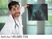 smiling male doctor holding pelvic x-ray. Стоковое фото, агентство Ingram Publishing / Фотобанк Лори