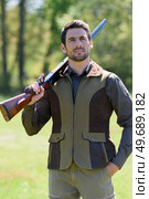 male farmer carrying a rifle walks along. Стоковое фото, агентство Ingram Publishing / Фотобанк Лори