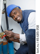 smiling worker demonstrates the choice of plastic pipes. Стоковое фото, агентство Ingram Publishing / Фотобанк Лори