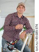 smile man posing near ladder. Стоковое фото, агентство Ingram Publishing / Фотобанк Лори
