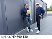 two men in safety helmets vests and working clothes. Редакционное фото, агентство Ingram Publishing / Фотобанк Лори