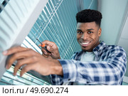 man is installing window blinds. Стоковое фото, агентство Ingram Publishing / Фотобанк Лори