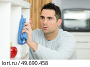 a man dusting at home. Стоковое фото, агентство Ingram Publishing / Фотобанк Лори