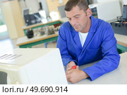 a tired technician fixing an oven. Стоковое фото, агентство Ingram Publishing / Фотобанк Лори