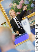 female auctioneer directing the bids. Стоковое фото, агентство Ingram Publishing / Фотобанк Лори