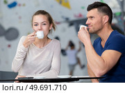 man and woman drinking coffees in indoor climbing center. Стоковое фото, агентство Ingram Publishing / Фотобанк Лори
