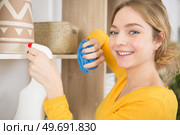 happy lady dusting shop shelf. Стоковое фото, агентство Ingram Publishing / Фотобанк Лори