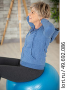 senior woman using exercise ball in a studio. Стоковое фото, агентство Ingram Publishing / Фотобанк Лори