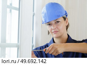 young woman tightens window screw. Стоковое фото, агентство Ingram Publishing / Фотобанк Лори