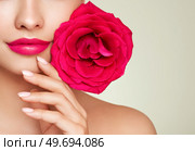 Beautiful model with a rose. Perfect woman face makeup close up. Lipstick. Beautiful nails. Nice smile. Perfect skin. Стоковое фото, агентство Ingram Publishing / Фотобанк Лори