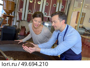 a couple scooping the coffee beans. Стоковое фото, агентство Ingram Publishing / Фотобанк Лори