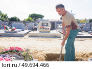 a man is digging grave. Стоковое фото, агентство Ingram Publishing / Фотобанк Лори