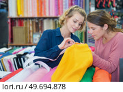 young women customers buying fabric. Стоковое фото, агентство Ingram Publishing / Фотобанк Лори