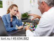 doctor explaining anatomical spine to his patient in medical office. Стоковое фото, агентство Ingram Publishing / Фотобанк Лори