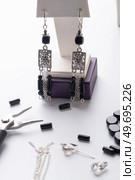 author ethno errings demonstrated  with tool and details against  white background. fashion and jewelry concept. Стоковое фото, агентство Ingram Publishing / Фотобанк Лори