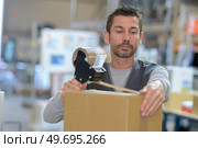 man securing the order inside the box. Стоковое фото, агентство Ingram Publishing / Фотобанк Лори