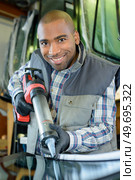 Man with large caulking gun. Стоковое фото, агентство Ingram Publishing / Фотобанк Лори