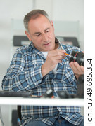 man cleaning lens by brush. Стоковое фото, агентство Ingram Publishing / Фотобанк Лори