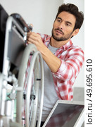 man is repairing a wheelchair at workshop. Стоковое фото, агентство Ingram Publishing / Фотобанк Лори