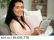 woman is solving crossword puzzles. Стоковое фото, агентство Ingram Publishing / Фотобанк Лори