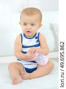 Baby holding a bottle. Стоковое фото, агентство Ingram Publishing / Фотобанк Лори
