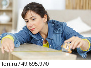woman measuring a piece of wood. Стоковое фото, агентство Ingram Publishing / Фотобанк Лори