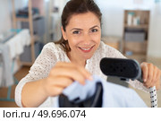 woman tailor ironing textile with steaming machine. Стоковое фото, агентство Ingram Publishing / Фотобанк Лори