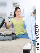 young woman packing a bag. Стоковое фото, агентство Ingram Publishing / Фотобанк Лори