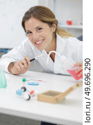 woman smiling while looking at a test tube. Стоковое фото, агентство Ingram Publishing / Фотобанк Лори