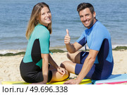 young couple of bodyboard surfers showing thumb-up. Стоковое фото, агентство Ingram Publishing / Фотобанк Лори