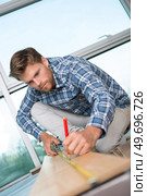 worker drawing a mark on laminate. Стоковое фото, агентство Ingram Publishing / Фотобанк Лори