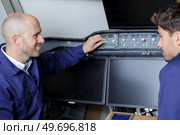 engineer talking to trainee in cockpit of aircraft. Стоковое фото, агентство Ingram Publishing / Фотобанк Лори