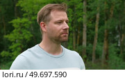 Handsome young man standing outdoors. Male thinking looking around feel happy, calm and serious. Green park background. Guy business employer, businessman manager inspired in nature. Diversity People. Стоковое видео, видеограф Марина Демидюк / Фотобанк Лори