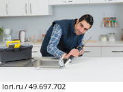 a worker plumber using sealant. Стоковое фото, агентство Ingram Publishing / Фотобанк Лори