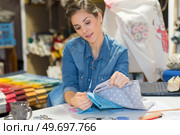 attractive seamstress comparing two material samples. Стоковое фото, агентство Ingram Publishing / Фотобанк Лори