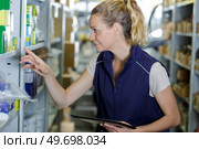 female warehouse worker with tablet selecting stock from racking. Стоковое фото, агентство Ingram Publishing / Фотобанк Лори