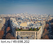 Aerial Paris cityscape with view to Sacre Coeur Basilica of the Sacred Heart, France. Beautiful parisian architecture with historic buildings, landmarks and busy city streets. Стоковое фото, агентство Ingram Publishing / Фотобанк Лори