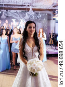 bride in a white dress throws a wedding bouquet to her unmarried girlfriends. Стоковое фото, агентство Ingram Publishing / Фотобанк Лори