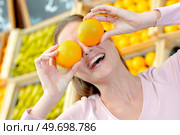 Lady holding oranges in front of her eyes. Стоковое фото, агентство Ingram Publishing / Фотобанк Лори