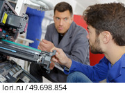 man training to fix a printer machine. Стоковое фото, агентство Ingram Publishing / Фотобанк Лори