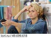 upset woman posing next to washing machine. Стоковое фото, агентство Ingram Publishing / Фотобанк Лори