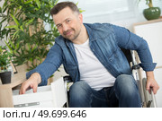 man in wheelchair reaching into a drawer. Стоковое фото, агентство Ingram Publishing / Фотобанк Лори