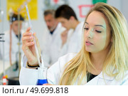 young woman testing a liquid. Стоковое фото, агентство Ingram Publishing / Фотобанк Лори