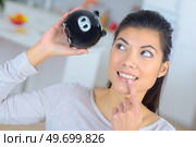young woman lifting piggy bank. Стоковое фото, агентство Ingram Publishing / Фотобанк Лори