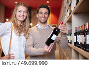 young couple deciding which wine to buy. Стоковое фото, агентство Ingram Publishing / Фотобанк Лори