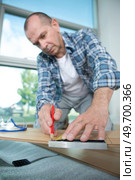male worker lying parquet floor board- laminate flooring. Стоковое фото, агентство Ingram Publishing / Фотобанк Лори