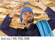 worker specialist plumber holding pipes in ceiling. Стоковое фото, агентство Ingram Publishing / Фотобанк Лори
